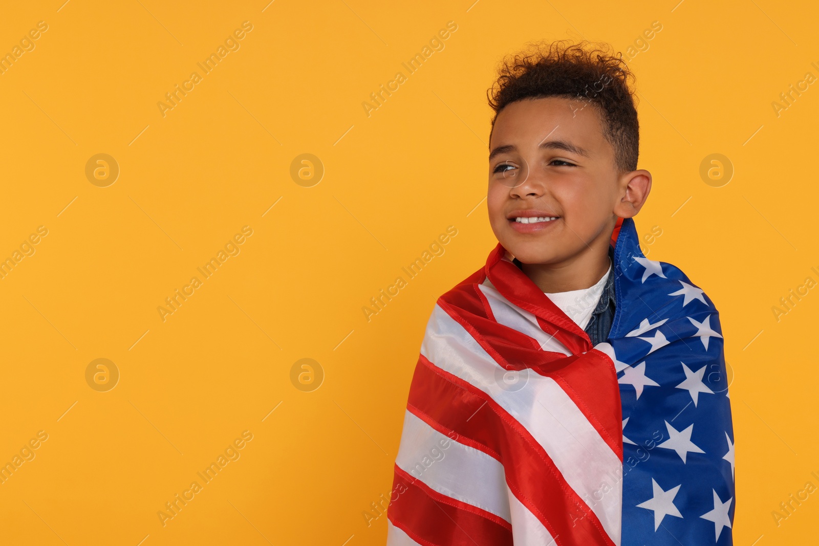 Photo of 4th of July - Independence Day of USA. Happy boy with American flag on yellow background, space for text