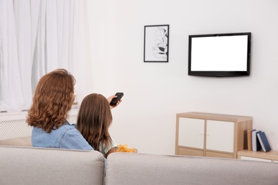 Photo of Family watching TV in room at home