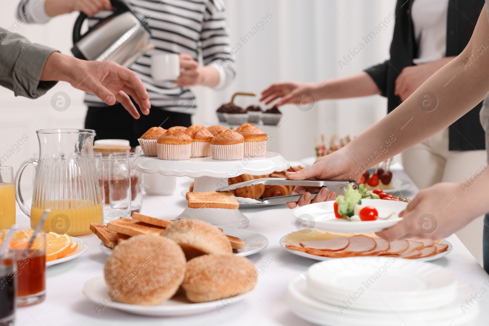 Photo of Coworkers having business lunch at white table indoors, closeup