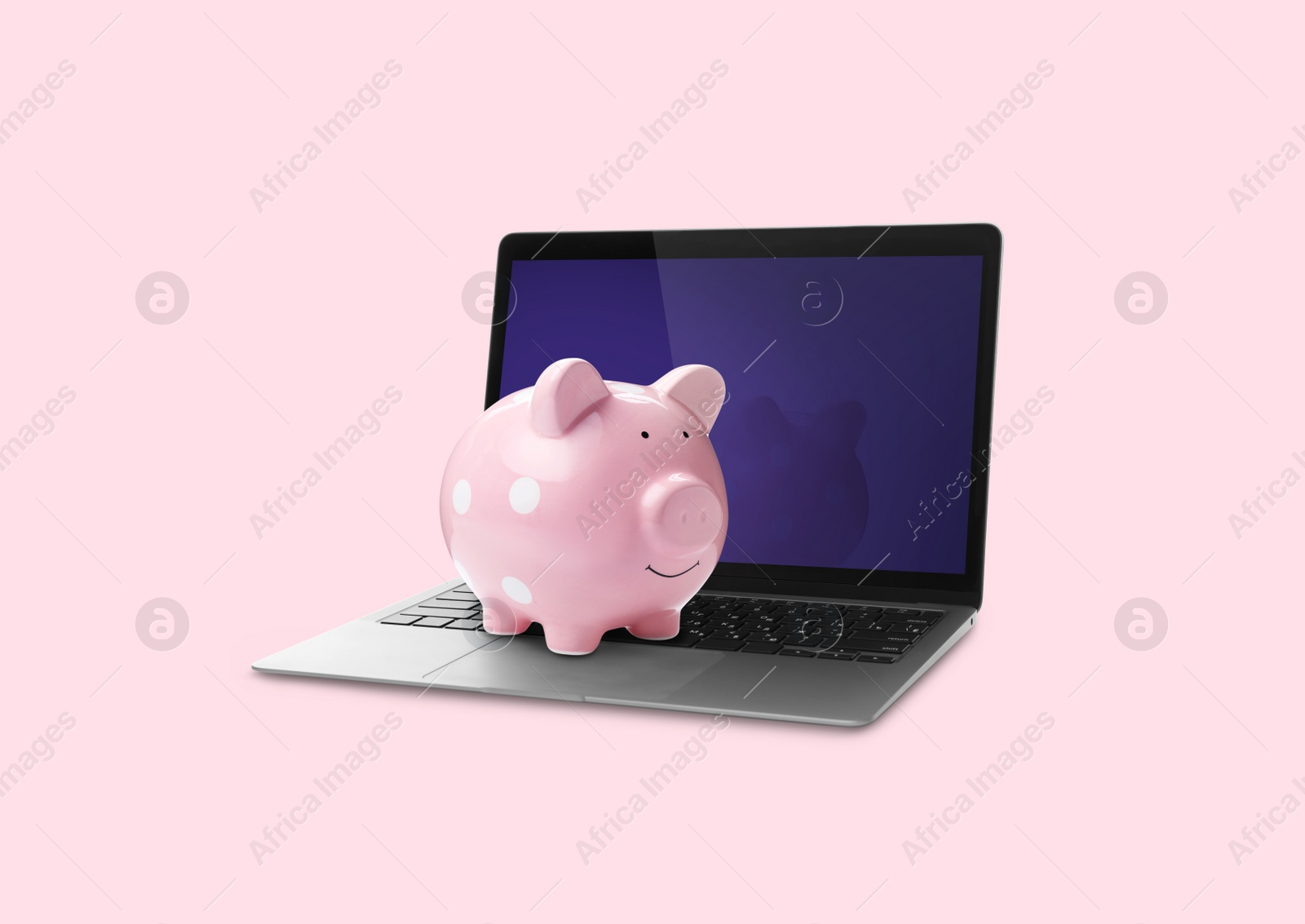 Image of Piggy bank and laptop on pink background. Online banking