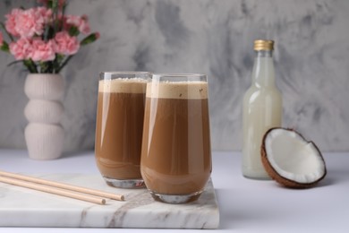 Delicious coffee with coconut syrup on white table