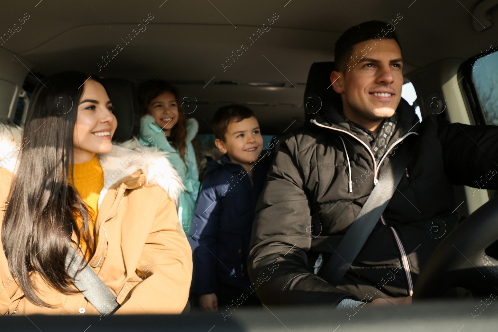 Photo of Happy family with little children inside modern car