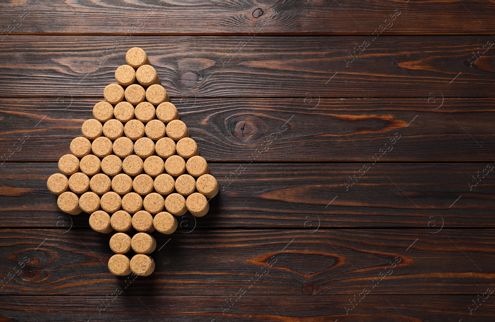 Photo of Christmas tree made of wine corks on wooden table, top view. Space for text