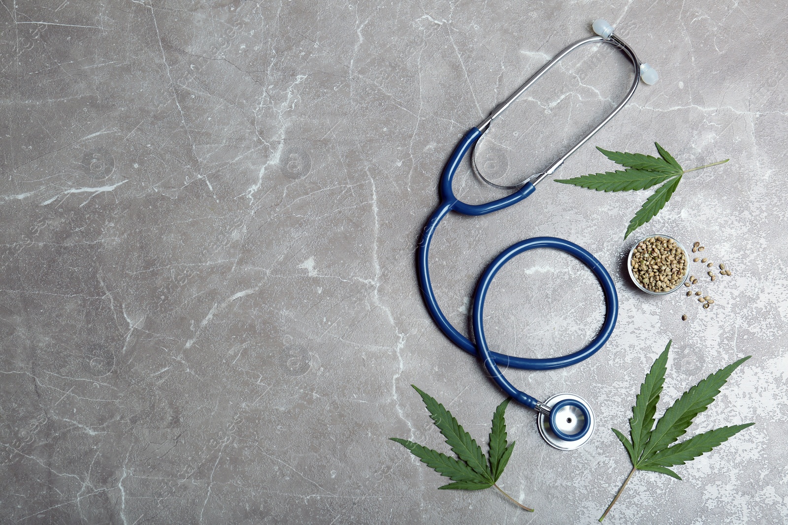 Photo of Flat lay composition with hemp leaves, stethoscope and space for text on grey background