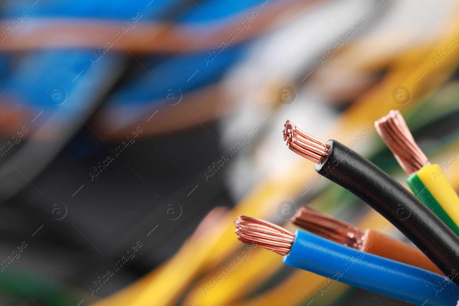 Photo of New colorful electrical wires on blurred background, closeup. Space for text