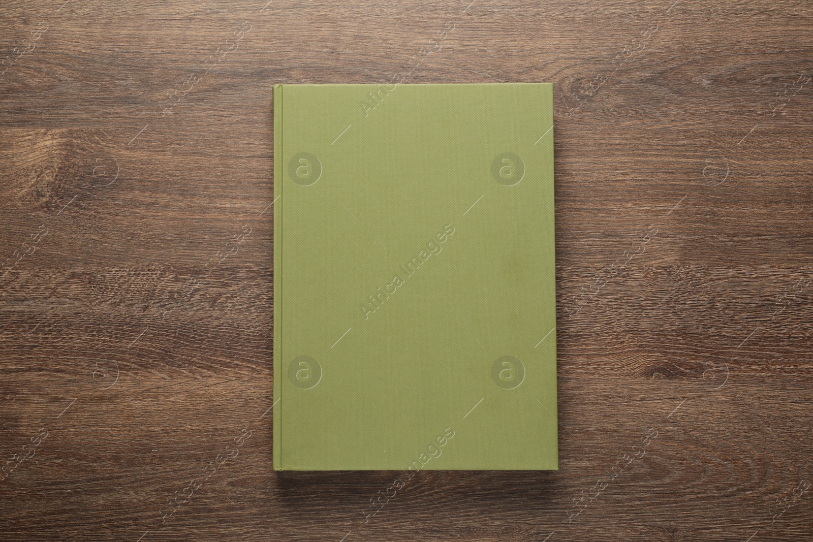 Photo of Closed hardcover book on wooden table, top view