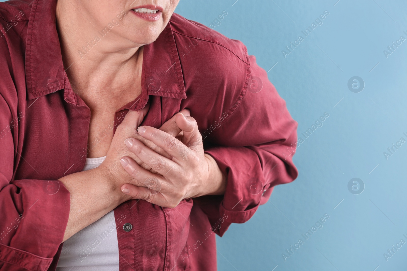 Photo of Mature woman having heart attack on color background