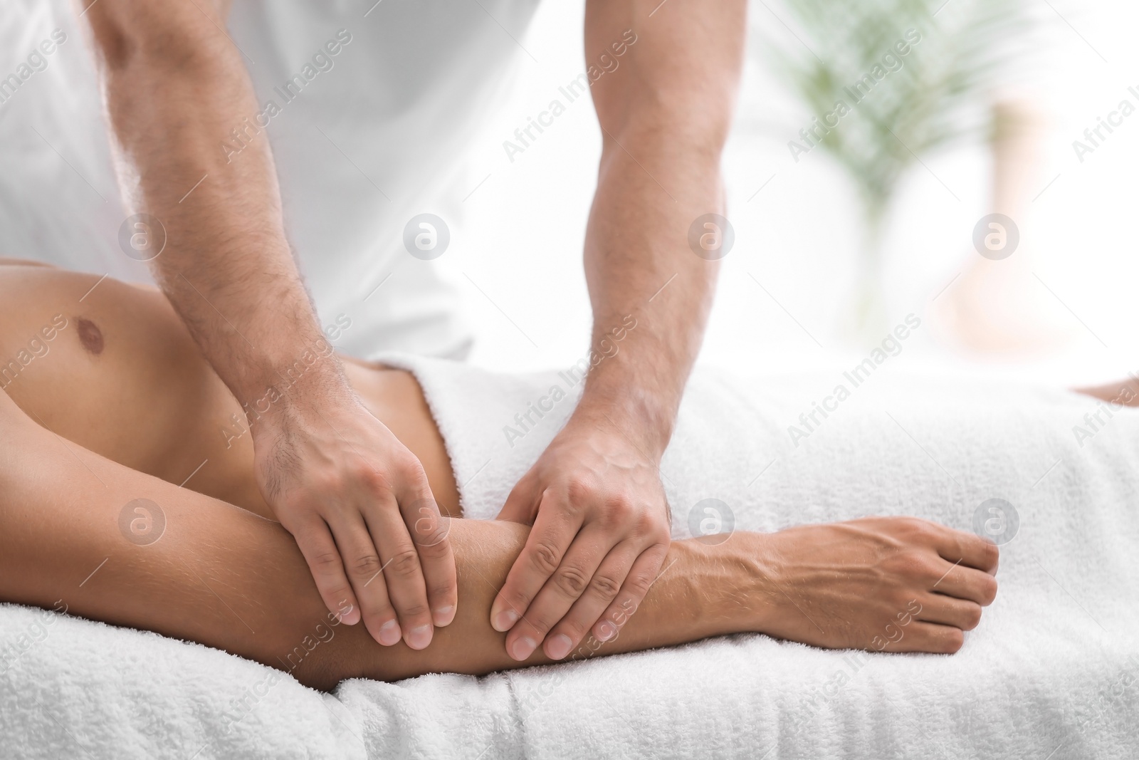 Photo of Young man receiving massage in salon, closeup