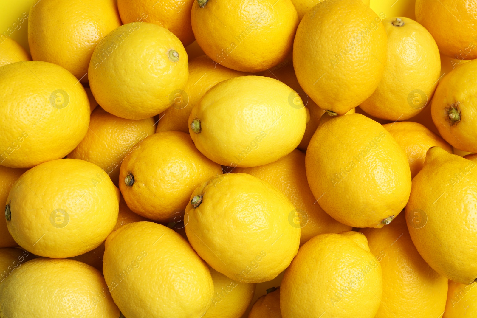 Photo of Many fresh ripe lemons as background, top view