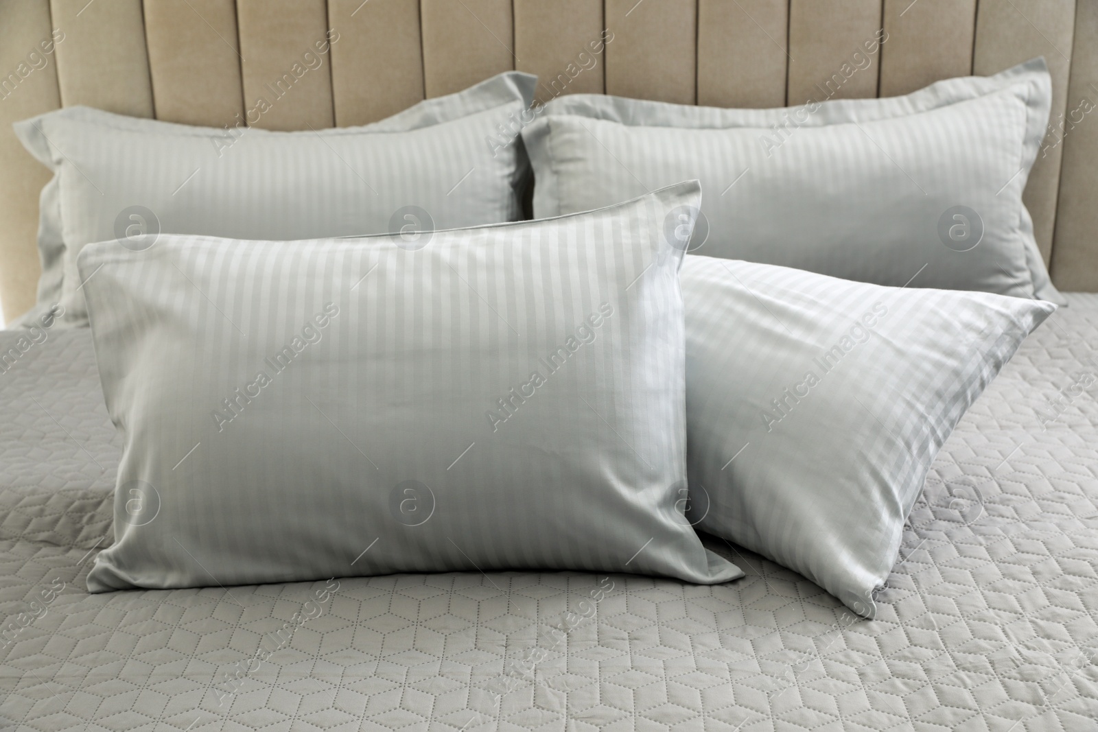 Photo of Many soft pillows on large comfortable bed