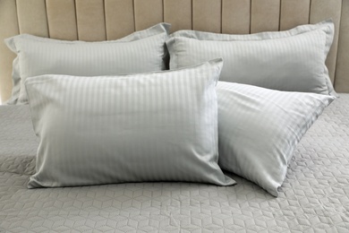 Many soft pillows on large comfortable bed
