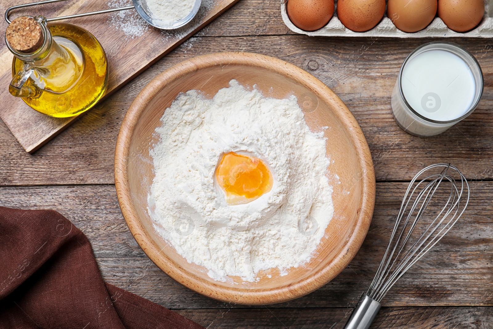 Photo of Flat lay composition with ingredients for thin pancakes on wooden table