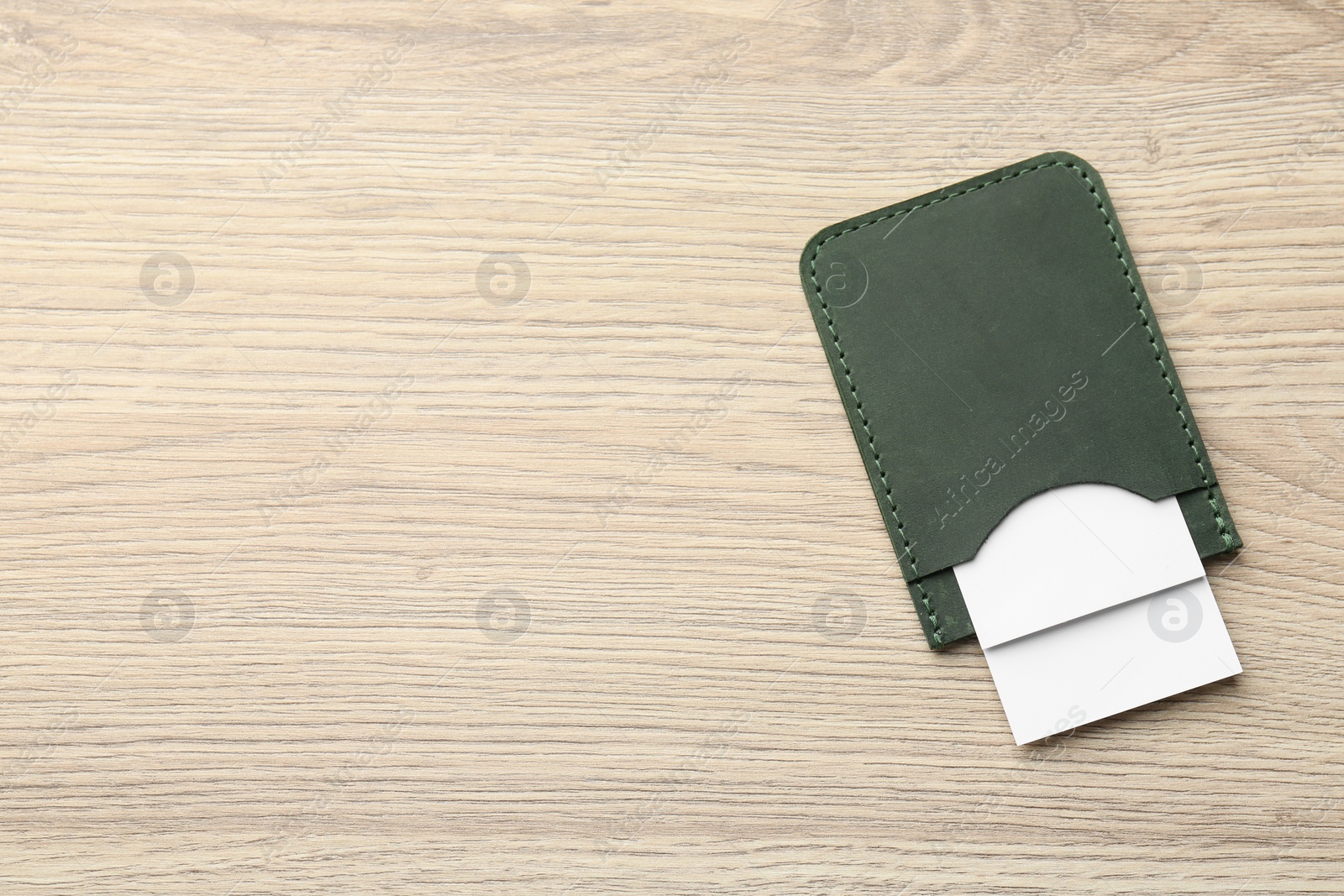 Photo of Leather business card holder with cards on wooden table, top view. Space for text