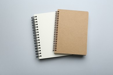 Photo of Notebooks on light grey background, top view