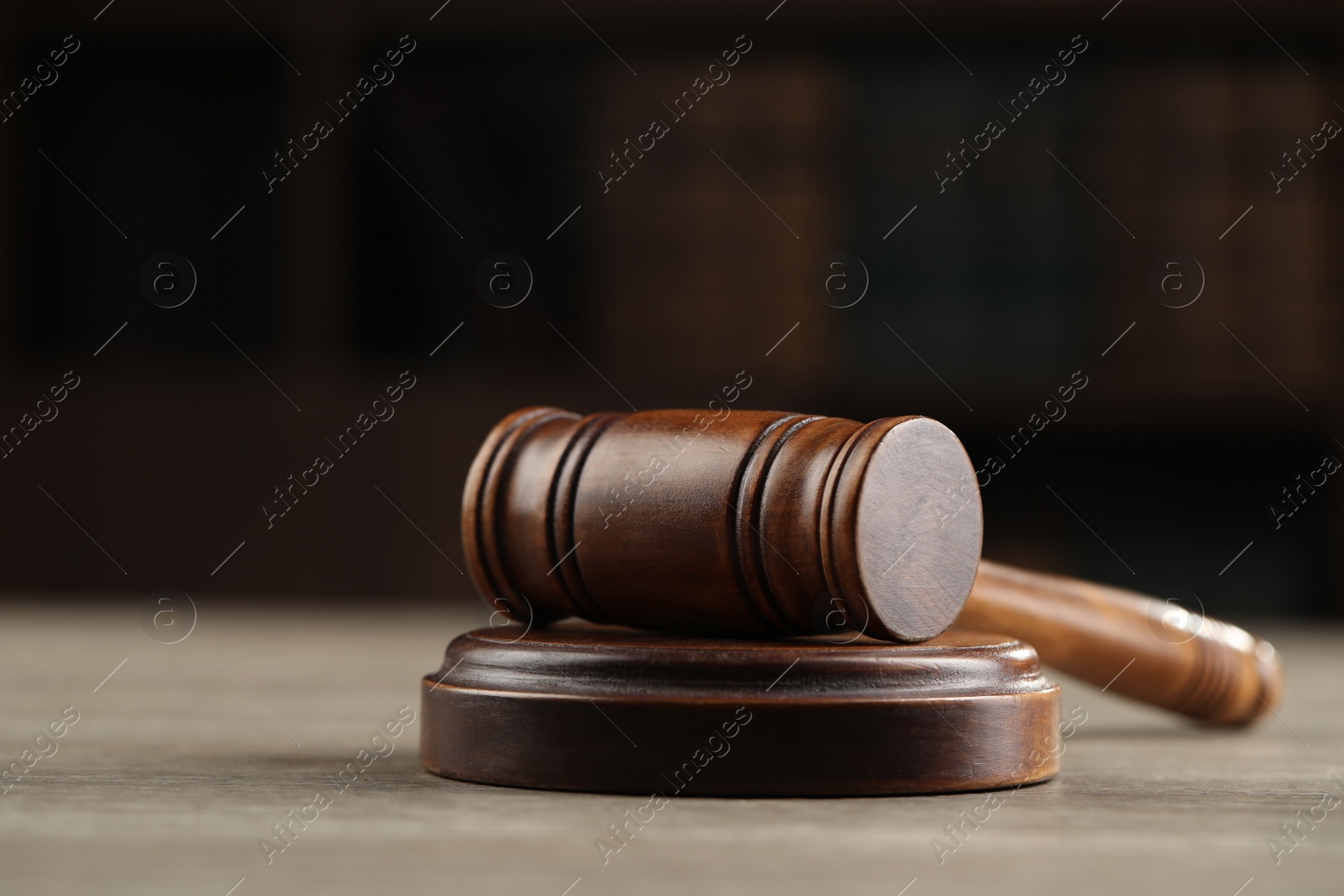 Photo of Wooden gavel on table against dark background, closeup