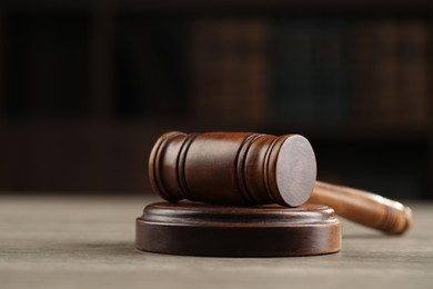 Photo of Wooden gavel on table against dark background, closeup