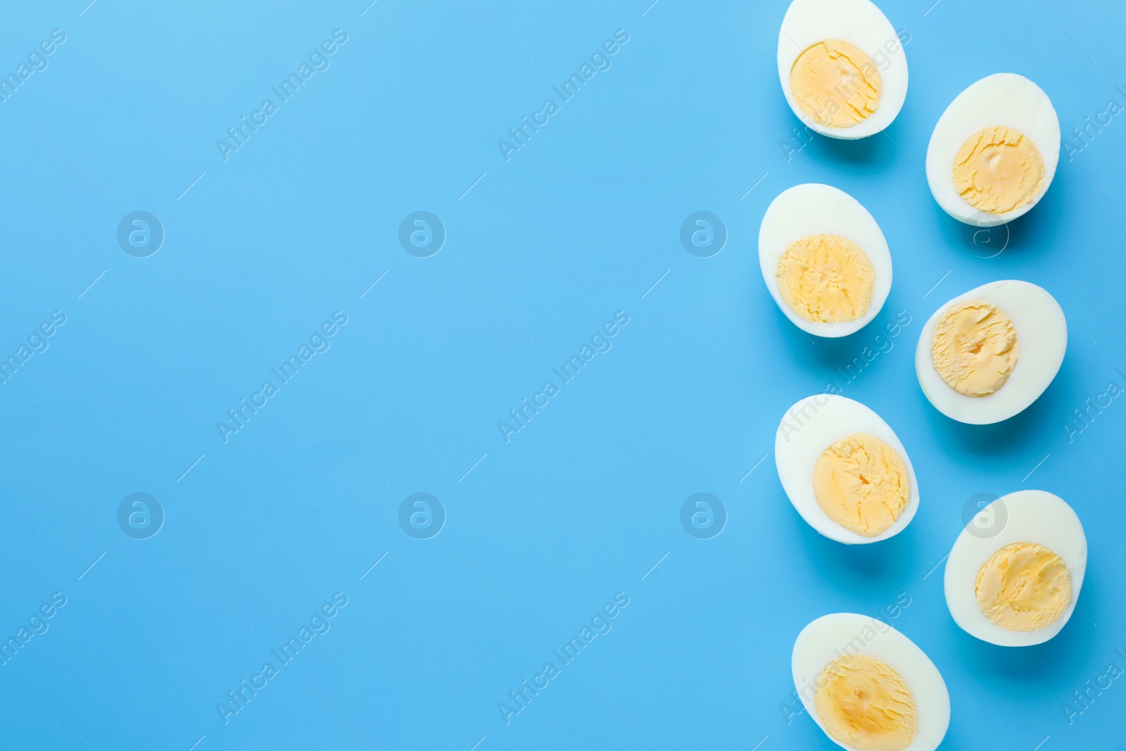 Photo of Fresh hard boiled eggs on light blue background, flat lay. Space for text