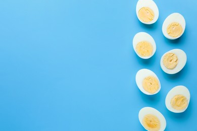 Photo of Fresh hard boiled eggs on light blue background, flat lay. Space for text
