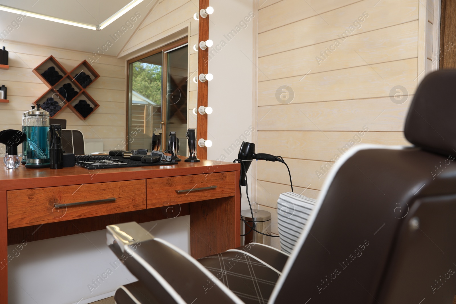 Photo of Stylish hairdresser's workplace with professional armchair in barbershop