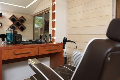 Stylish hairdresser's workplace with professional armchair in barbershop