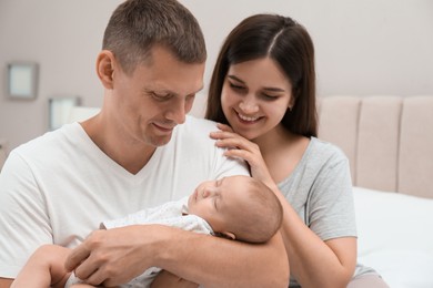 Happy family with their cute sleeping baby at home