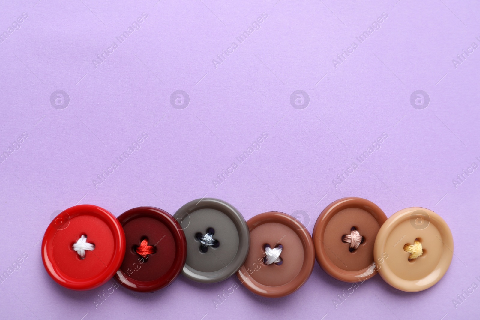 Photo of Many colorful sewing buttons on violet background, flat lay. Space for text