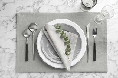 Photo of Stylish setting with cutlery, glasses and plates on white marble table, flat lay