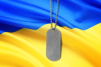 Military ID tag and Ukrainian flag on background