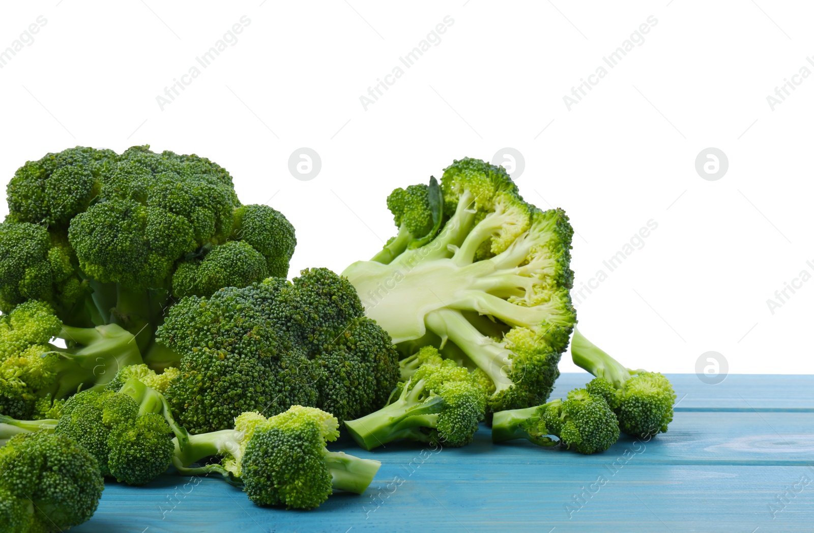 Photo of Fresh broccoli on light blue wooden table against white background