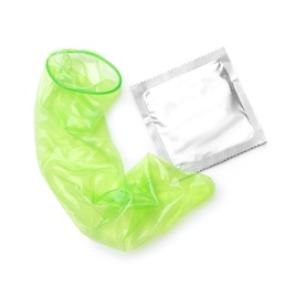 Unrolled green condom and package on white background, top view. Safe sex