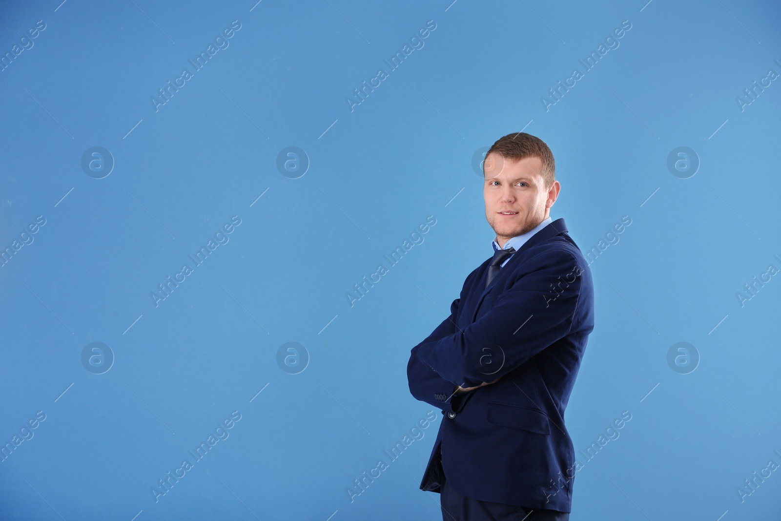 Photo of Business trainer with crossed arms on color background