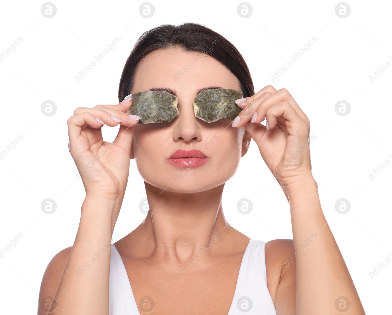 Photo of Beautiful woman applying green tea bags on skin under eyes against white background