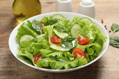 Photo of Delicious salad in bowl on wooden table, closeup