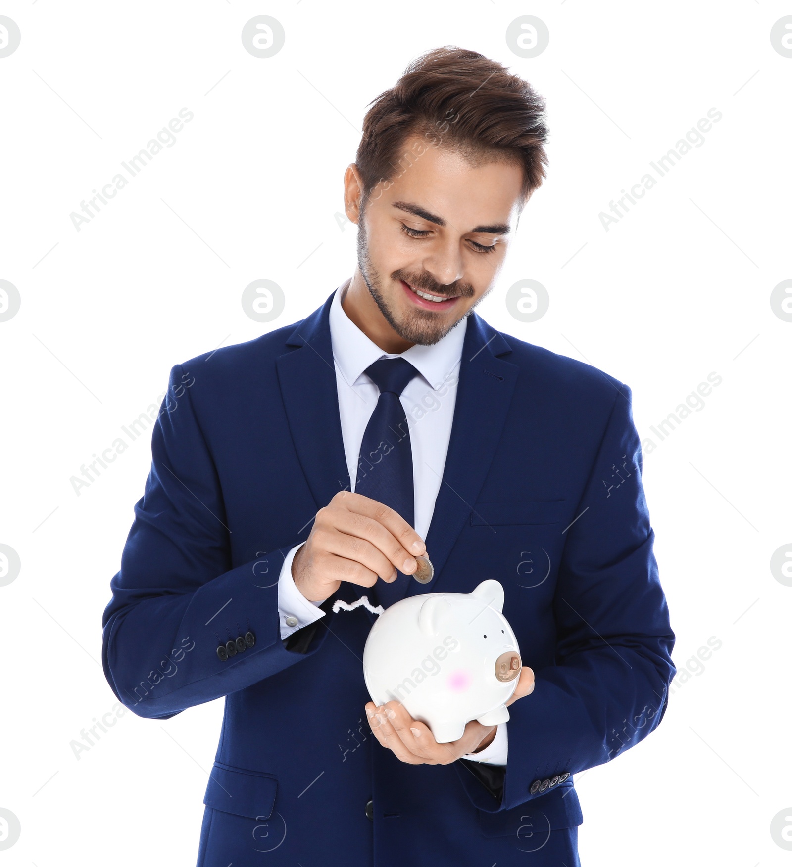 Photo of Young businessman putting money into piggy bank on white background