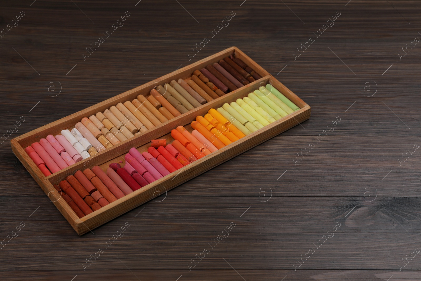 Photo of Drawing pastel set in box on wooden table. Space for text