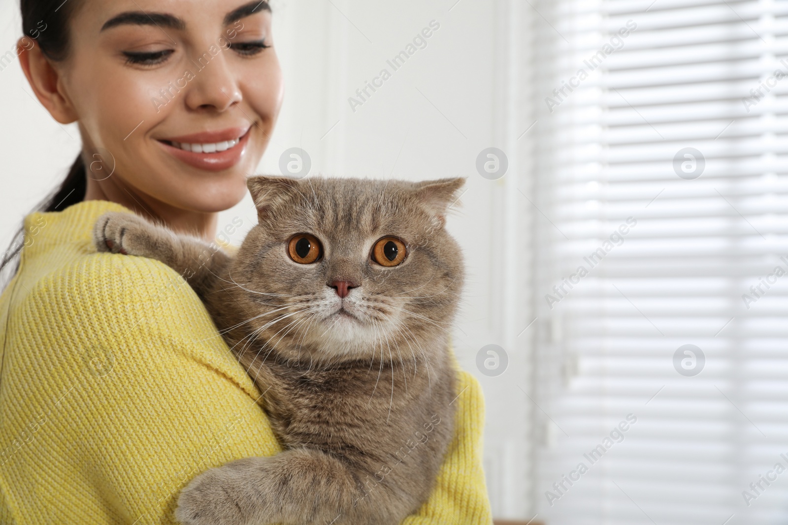 Photo of Woman with her adorable cat at home, space for text