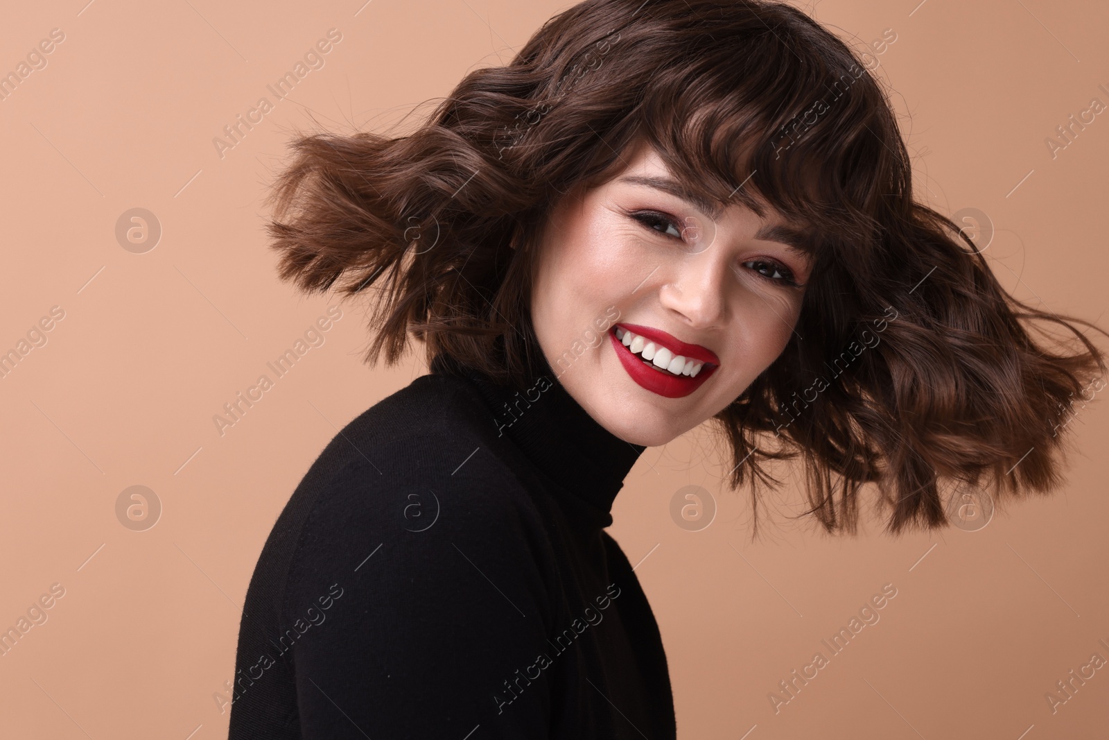 Photo of Portrait of beautiful young woman with wavy hairstyle on beige background