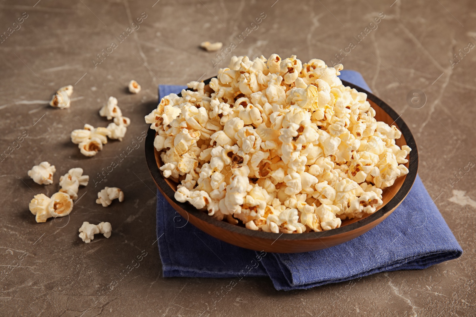 Photo of Bowl of tasty popcorn on grey background