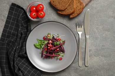 Photo of Delicious fresh carrot salad served on grey table, flat lay