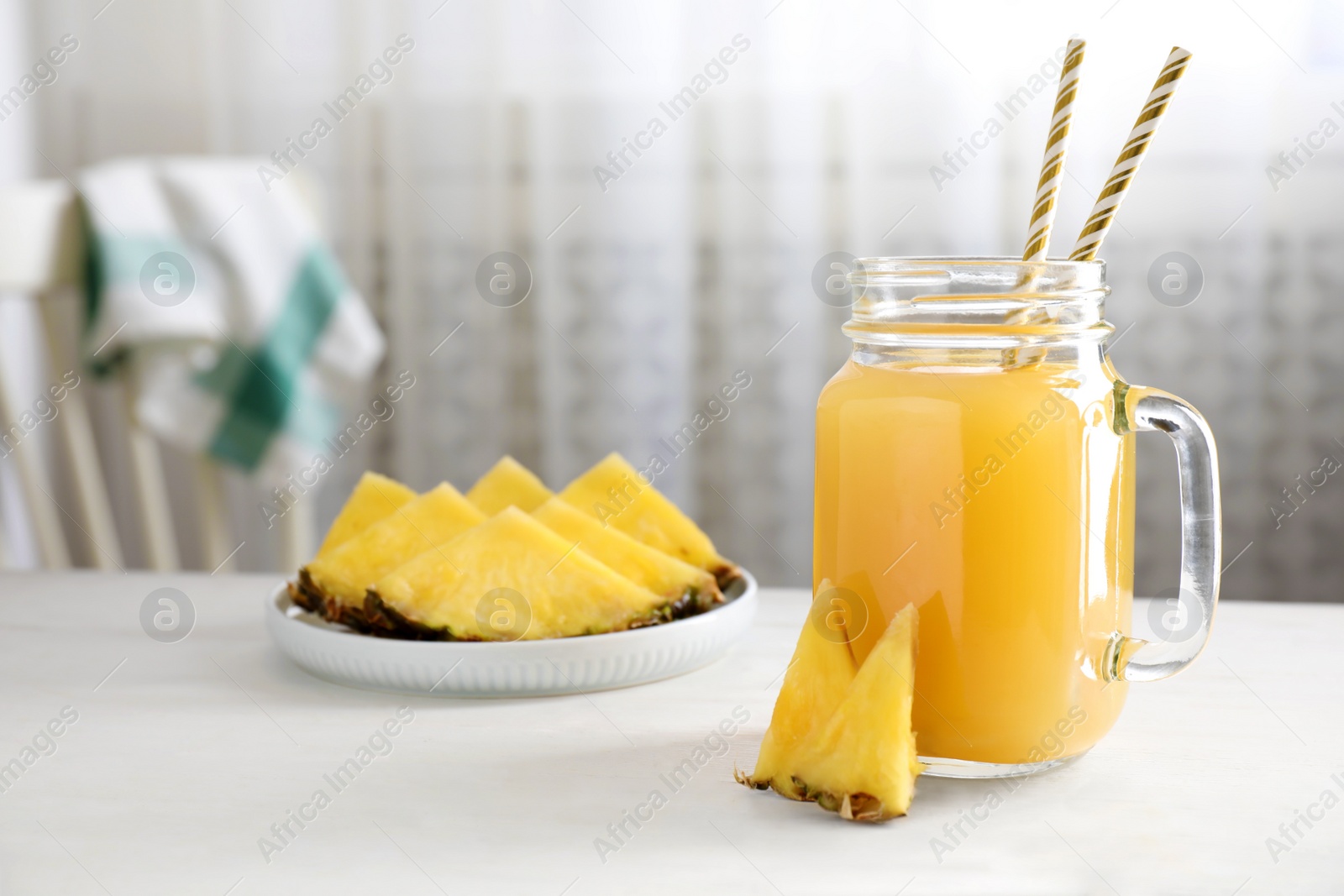 Photo of Delicious pineapple juice and fresh fruit on white table indoors. Space for text