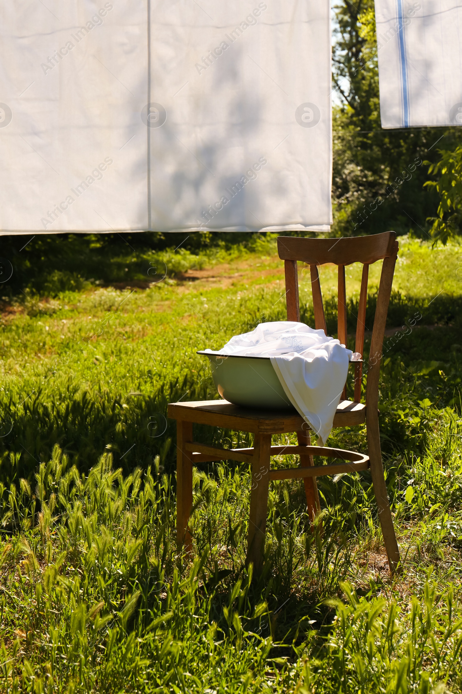 Photo of Washing line with clean laundry and clothespins outdoors