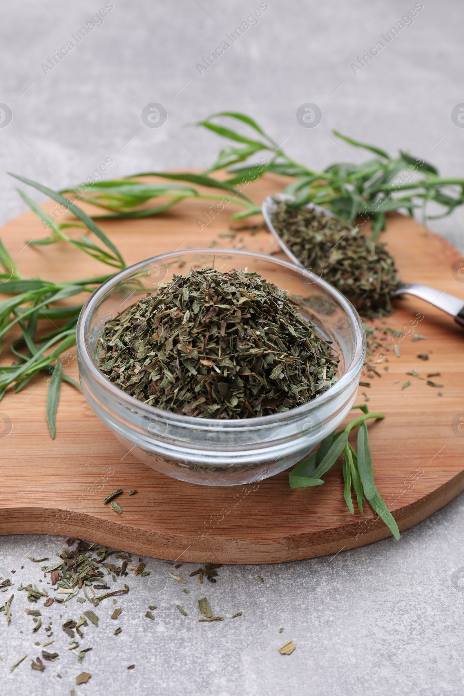 Photo of Dry and fresh tarragon on light gray textured table