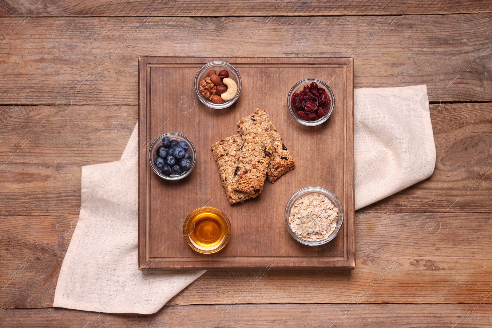 Photo of Tasty granola bars served on wooden table, top view