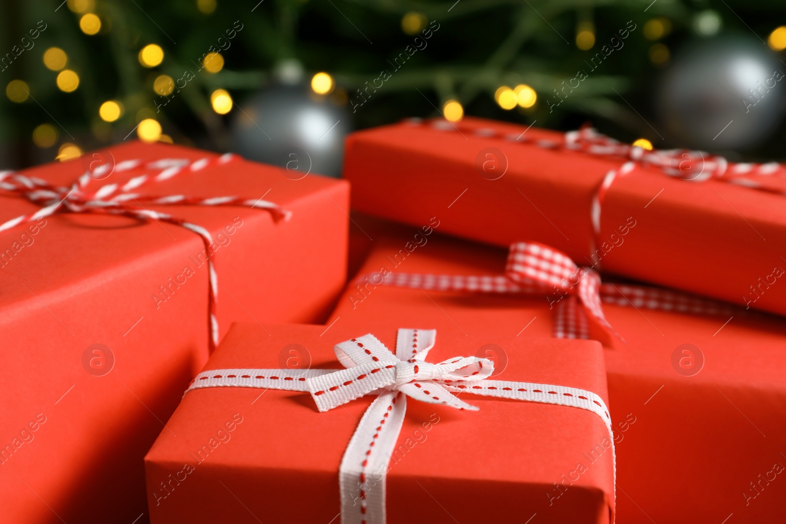 Photo of Beautiful gift boxes and blurred Christmas tree on background