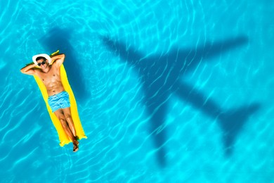 Shadow of airplane and happy man on inflatable mattress in swimming pool, top view. Summer vacation