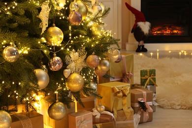 Photo of Many gift boxes under decorated Christmas tree at home