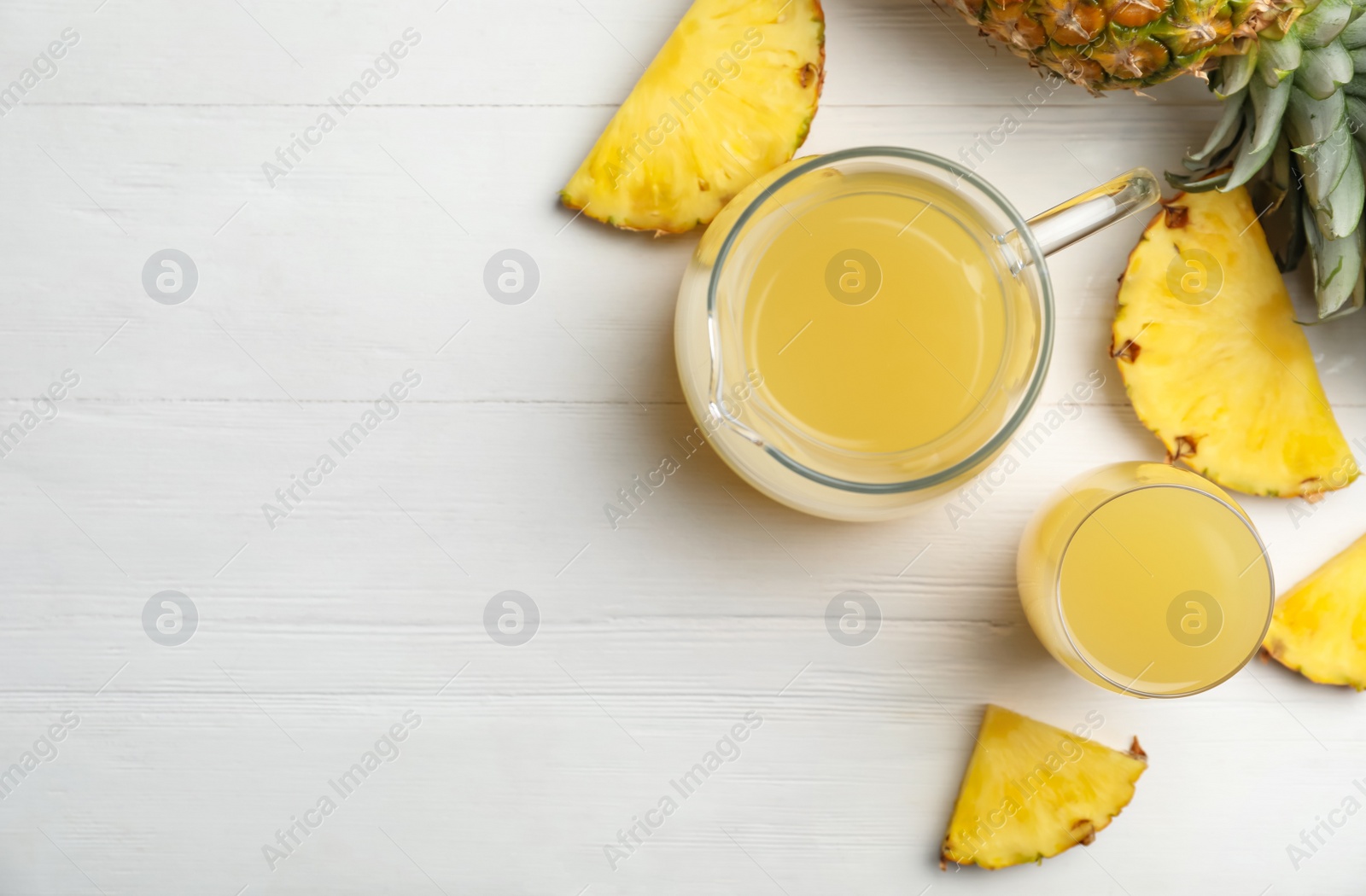 Photo of Delicious pineapple juice and fresh fruit on white wooden table, flat lay. Space for text