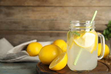 Photo of Cool freshly made lemonade and fruits on wooden table. Space for text