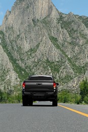 Photo of Black car on road near beautiful mountains outdoors