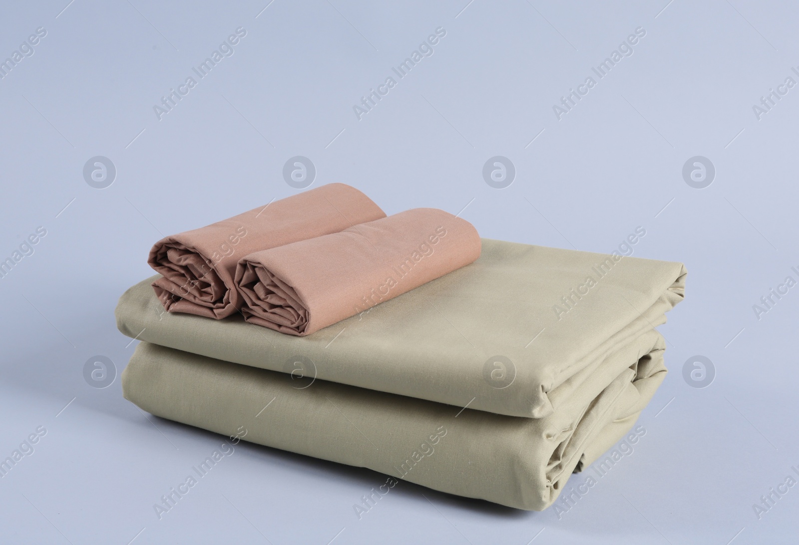 Photo of Stack of clean bed sheets on white background